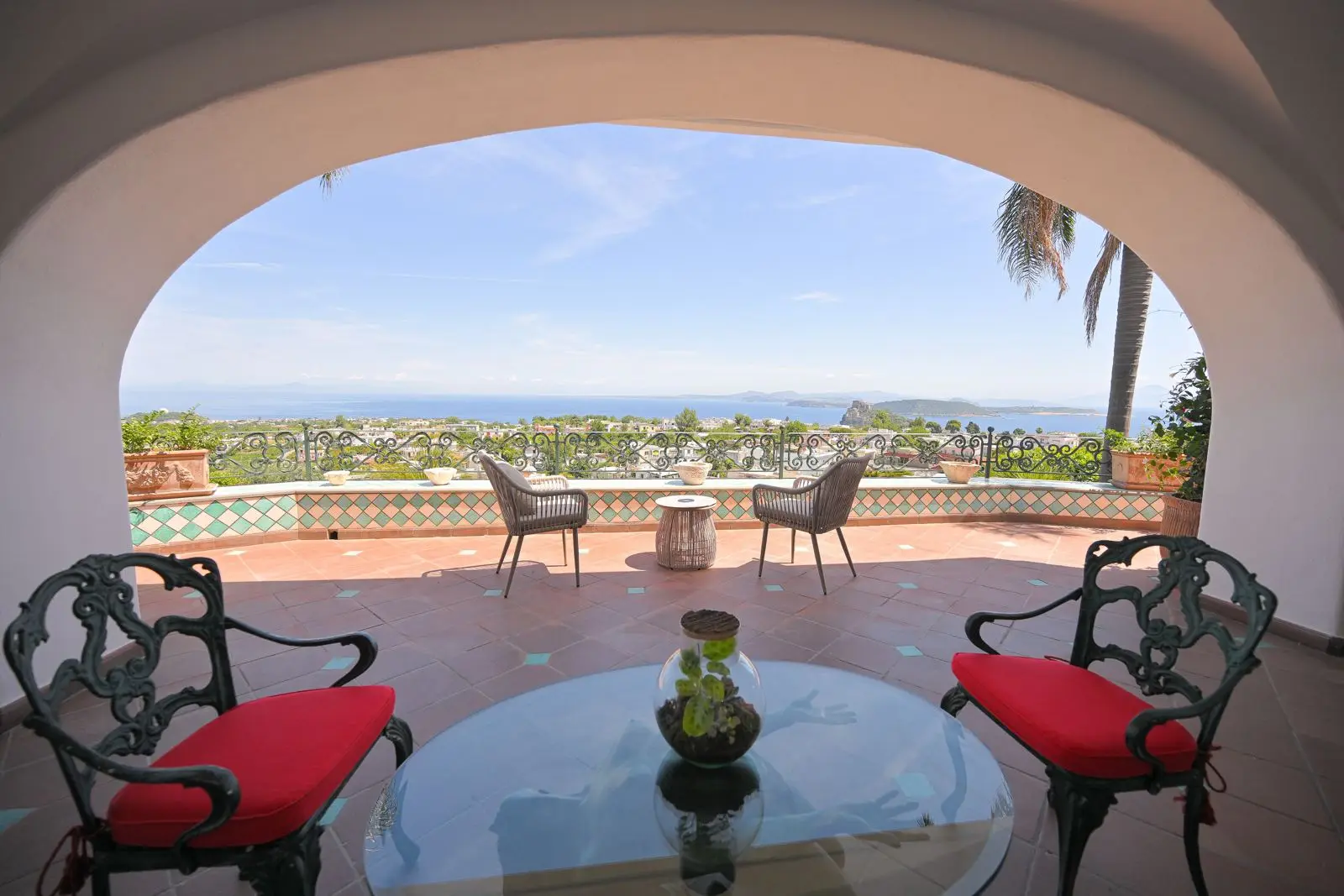 The Deluxe private terrace with red armchairs and the view over the gulf
