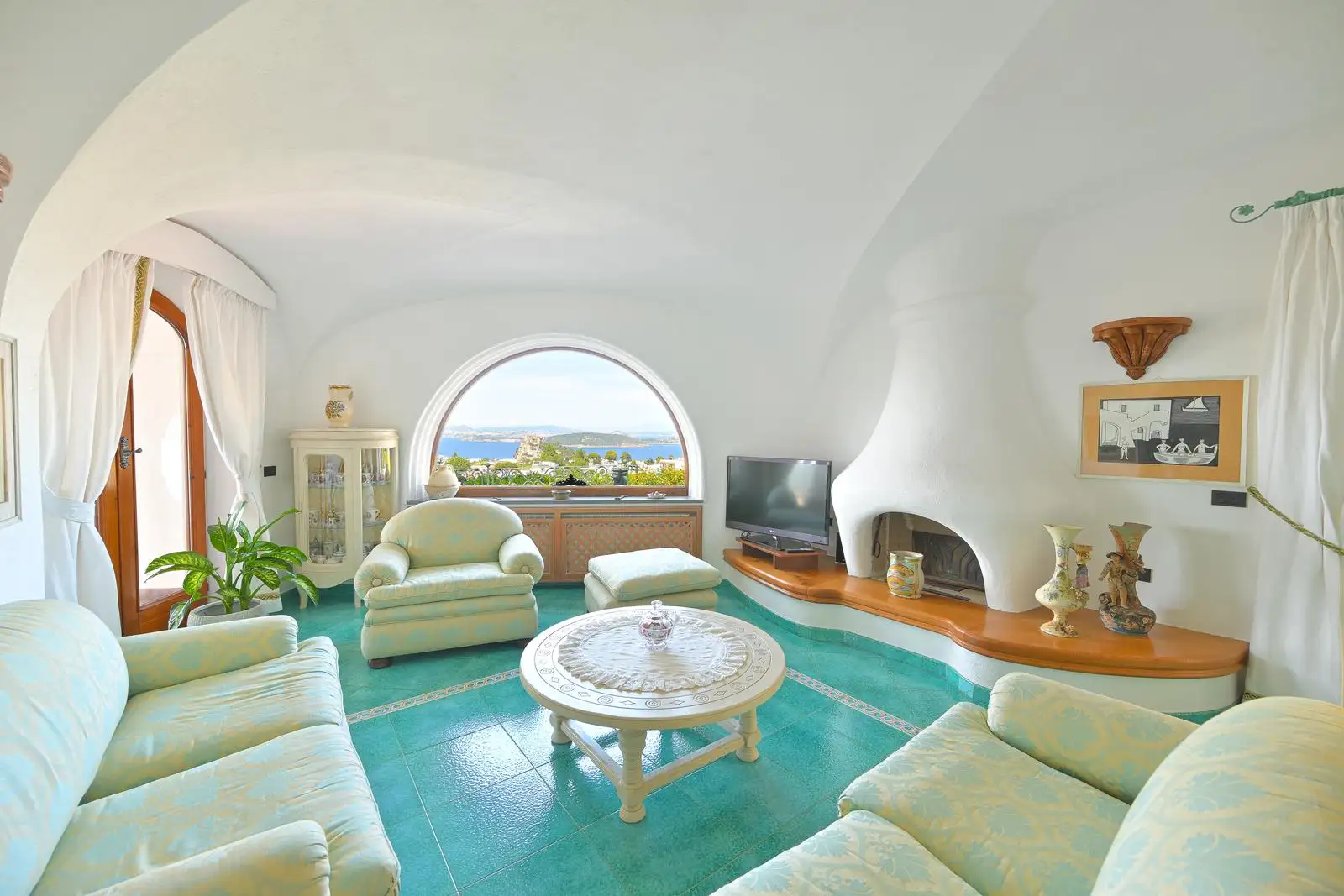 The sitting room with the white fireplace and the arched window onto the bay