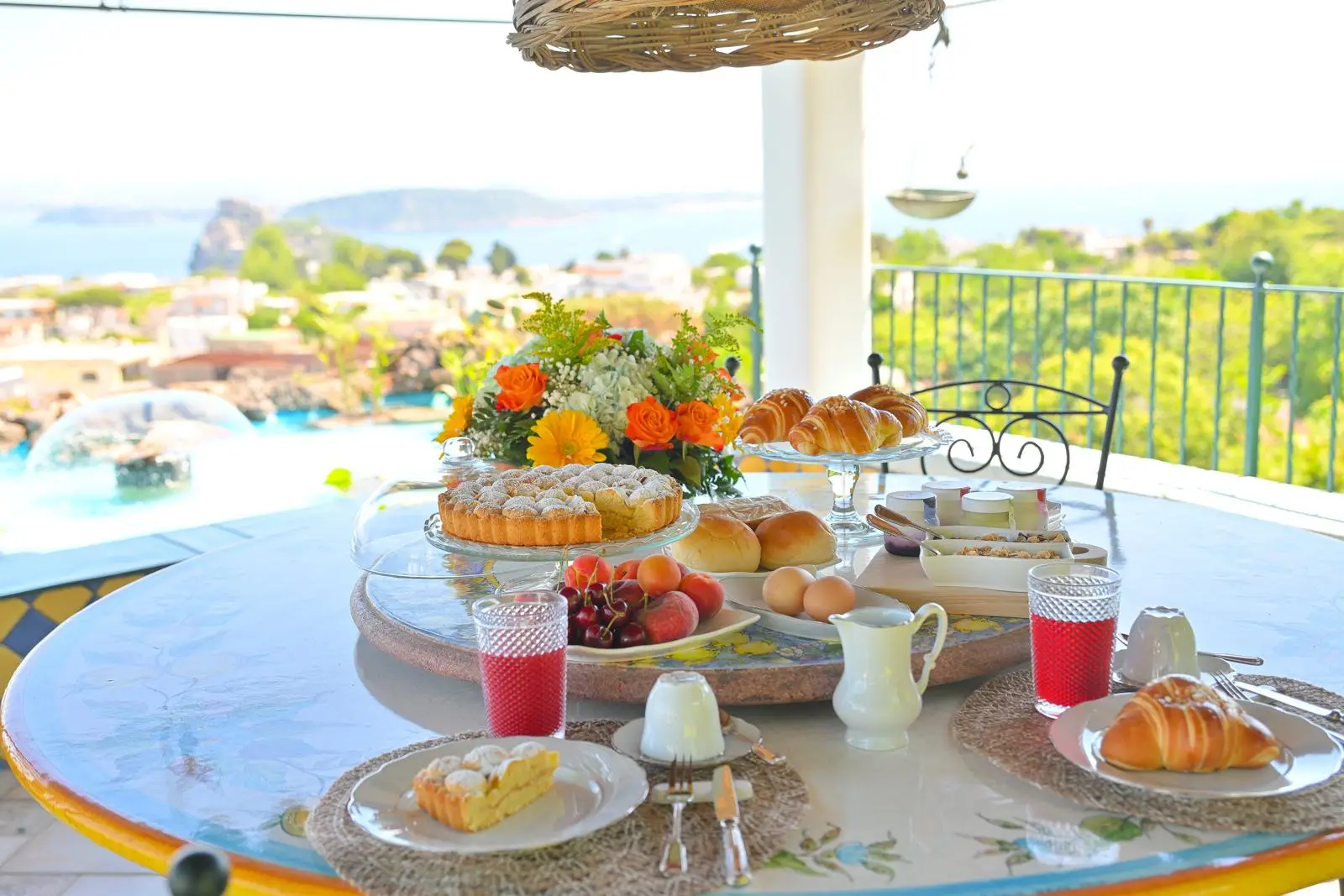 The breakfast table laid under the pergola above the pool