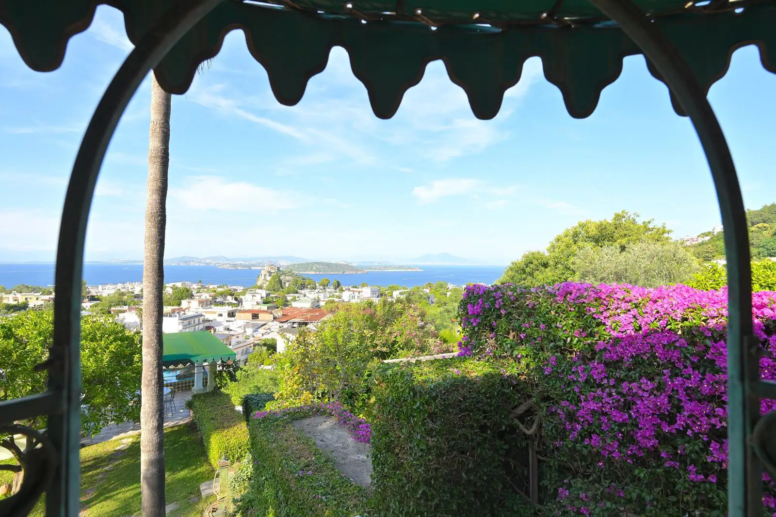 The wrought-iron gazebo wrapped in bougainvillea with the gulf beyond