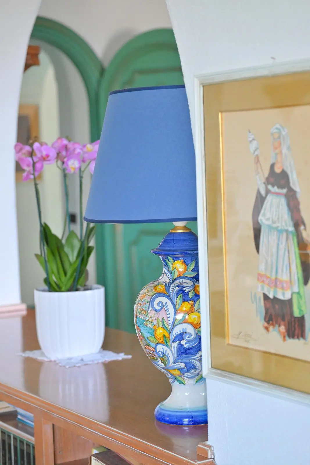 The hand-painted ceramic lamp with an orchid on the console